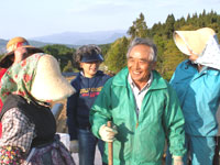 初日の農作業が終わりトマト部会長の杉山昭和さん（中央）は、組合員をねぎらう言葉をかけていました
