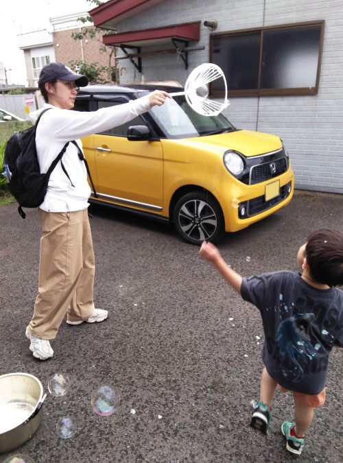 シャボン玉で遊ぶ大人と子ども